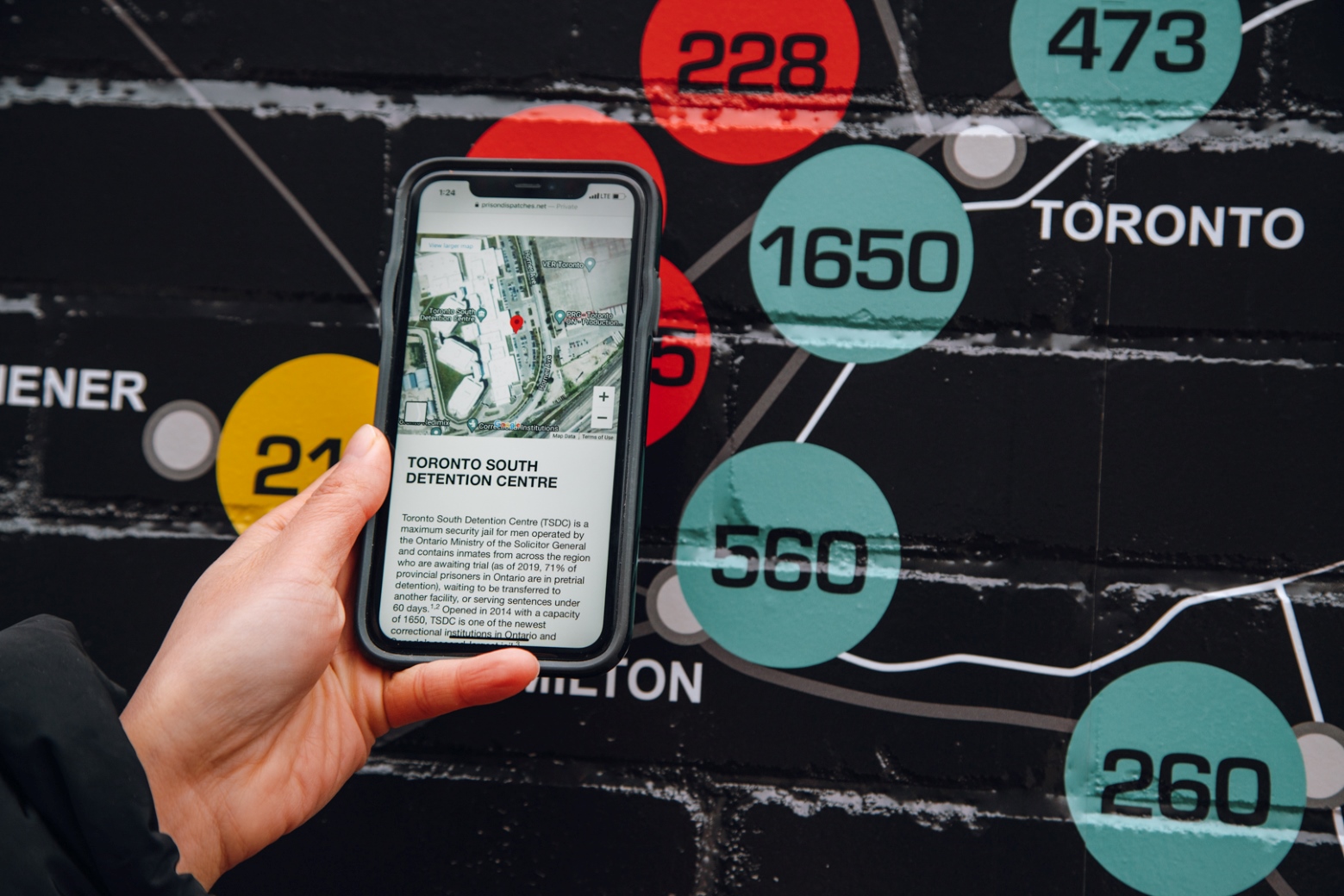 Woman holding cell phone showing an application.