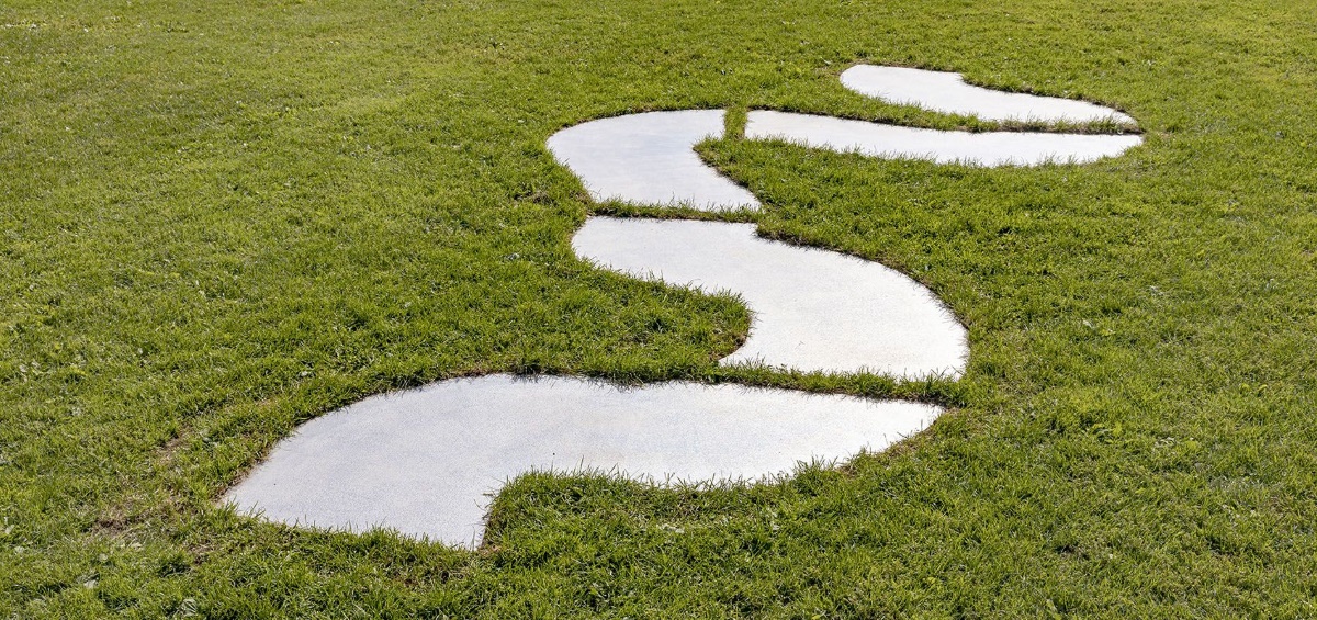 Geometric shapes of water or cement in green grass.