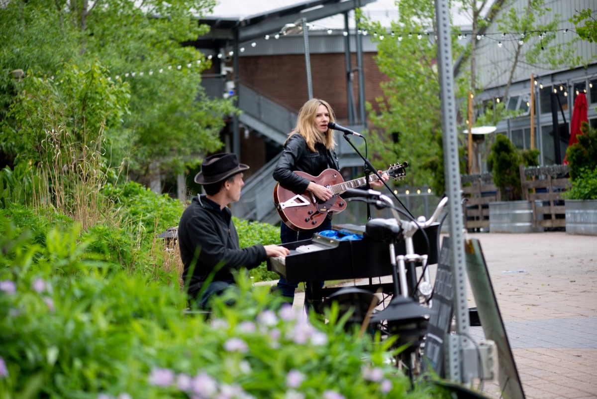 Woman singing along to a man playing piano.