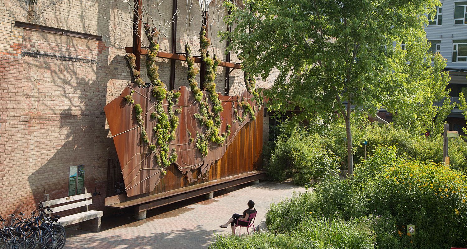 Person sits on bench looking at interactive public art