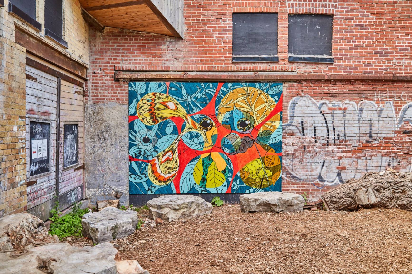 large, colourful mural against brick wall outdoors