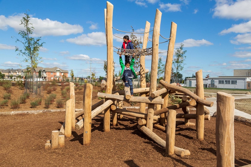 kids play on playground play structure made out of natural wood with ropes