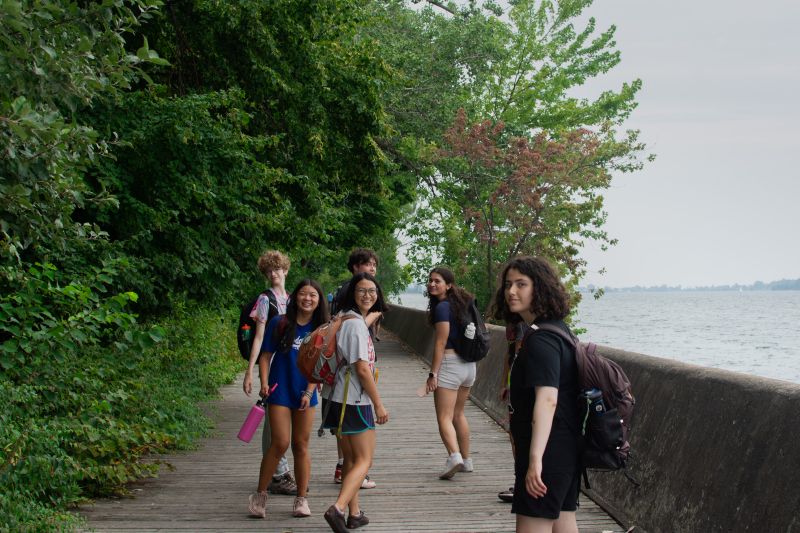 Group of youth walking on boardwalk looking at camera and smiling