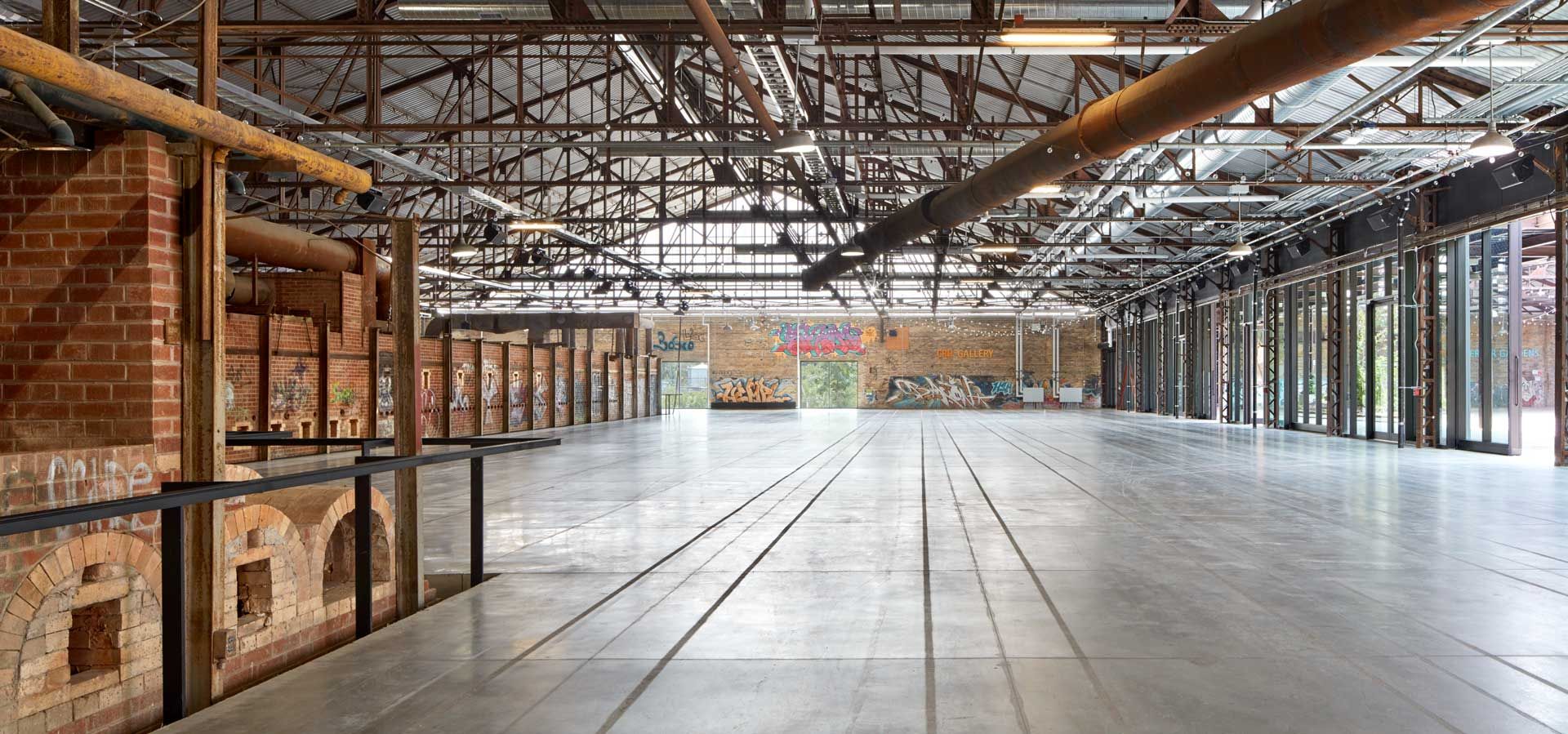 TD Future Cities Centre in the kilns building at Evergreen Brick Works. Exposed brick with graffiti, windows, brick kilns and exposed steel beams.