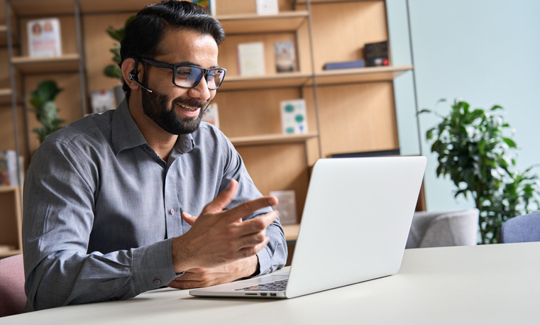Man advising someone else via his laptop and headset