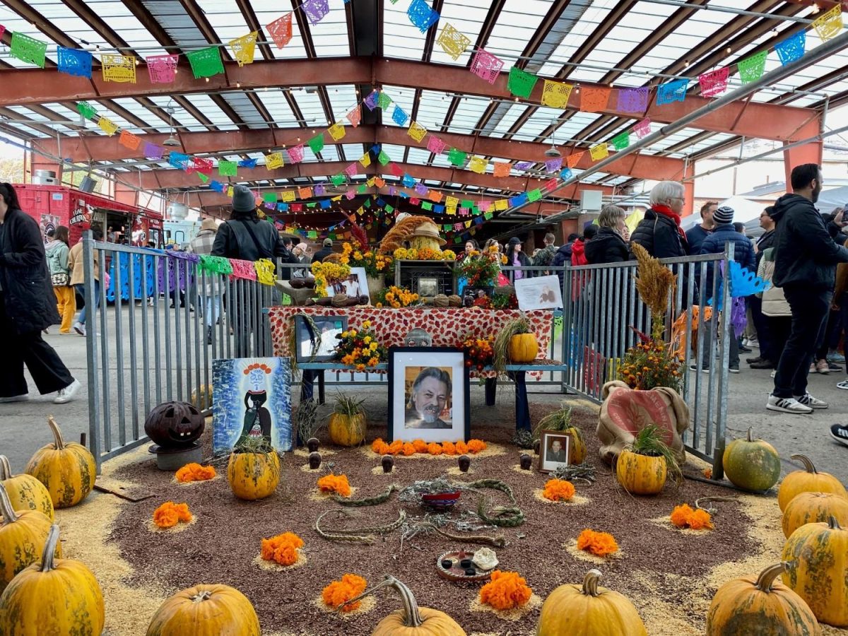 Community ofrenda including photographs, paintings, flowers and food offerings at the Good Mourning Festival - Day of the Dead Celebration