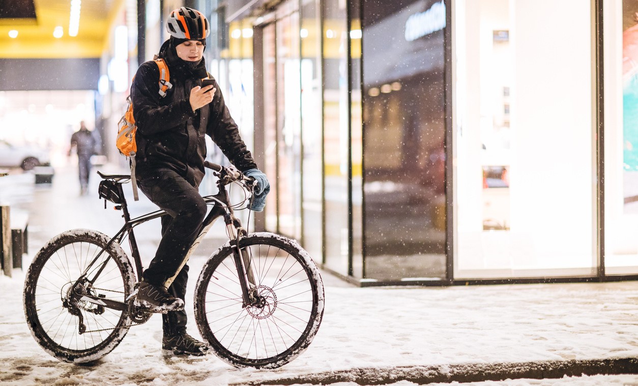 person on a bicycle in the city during the winter with snowy streets