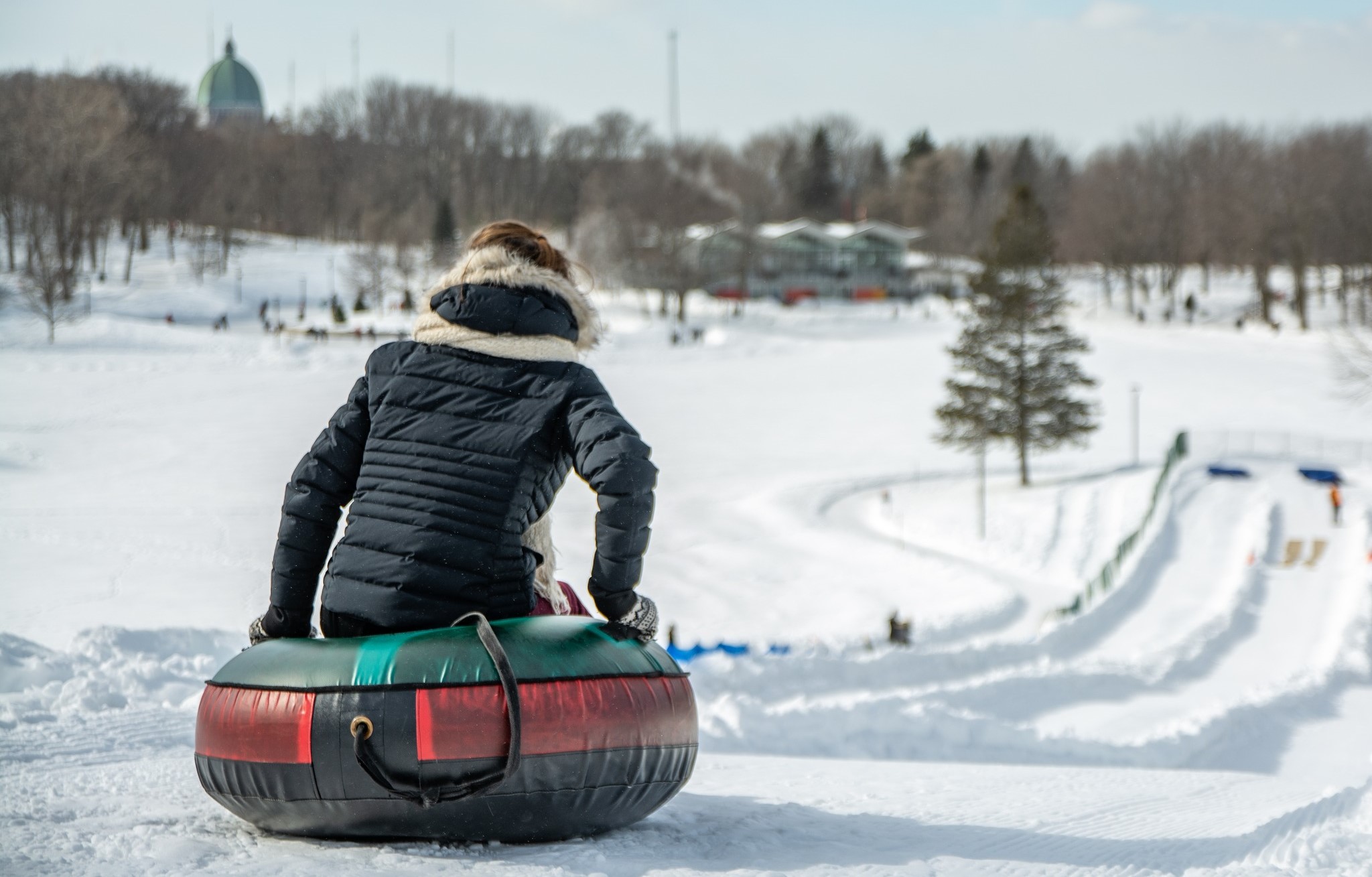Person on inner tube about to go down a snowy hill