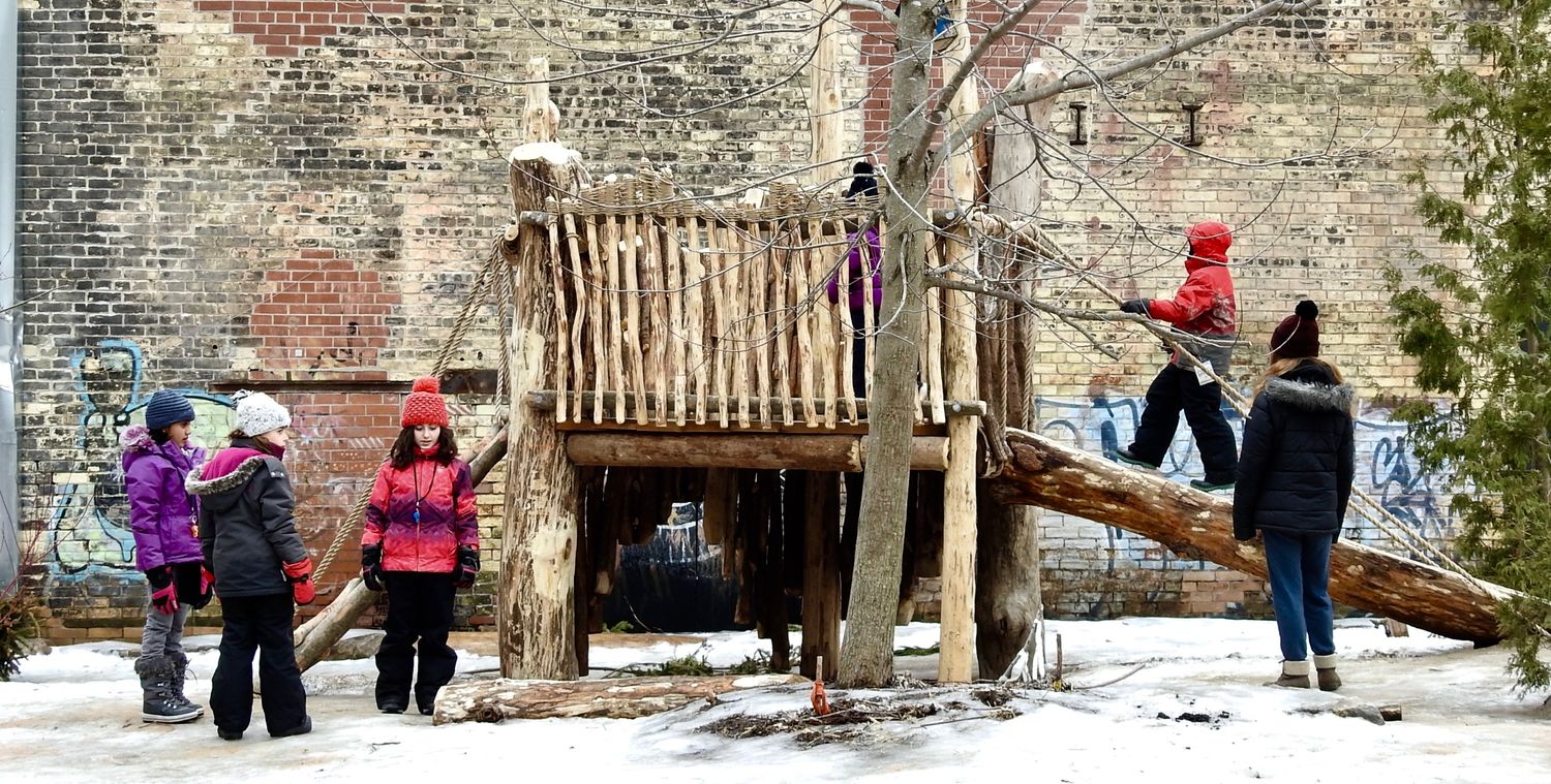 kids play on wooden structure in the snow