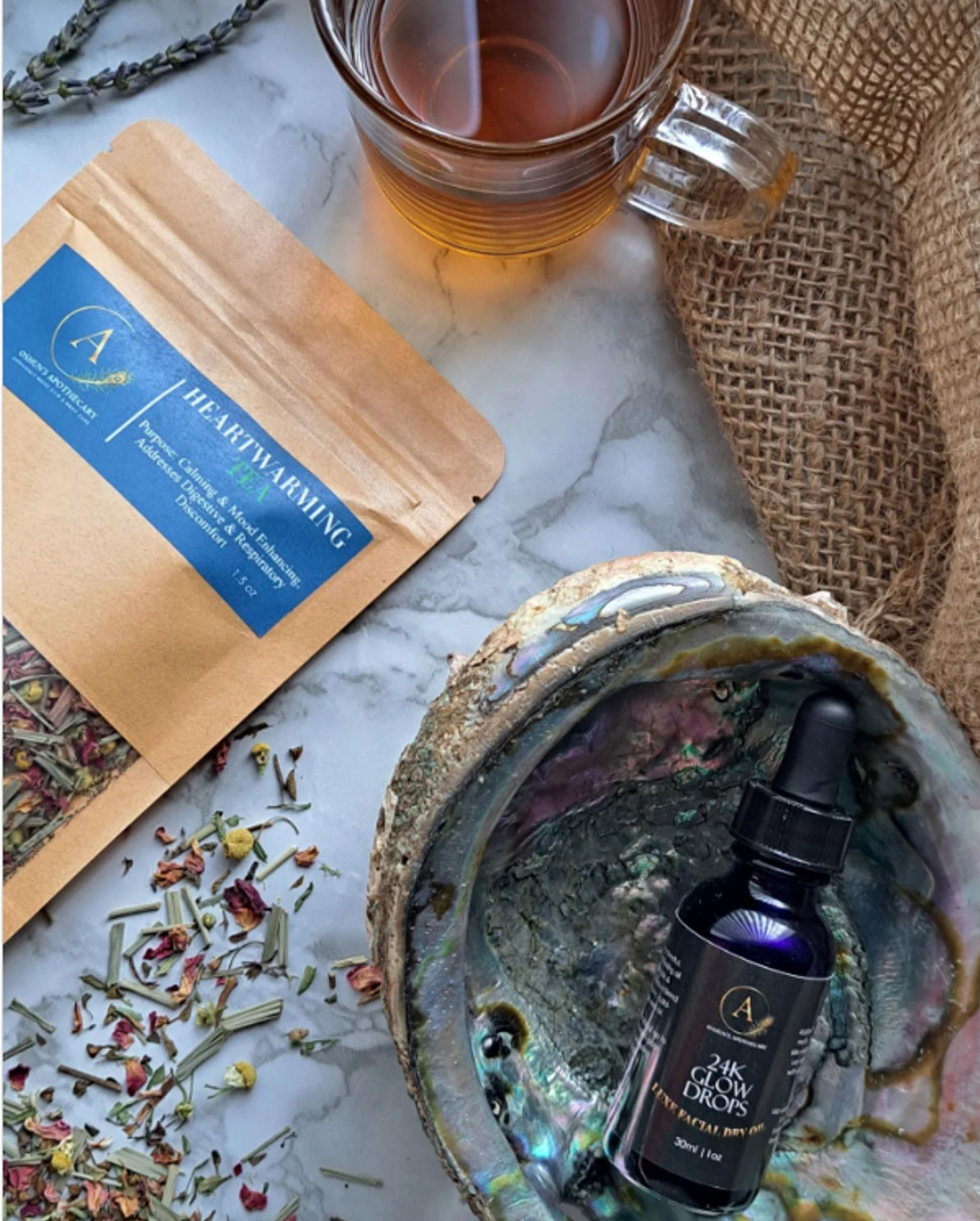 Loose leaf tea from Oshuns Apothecary on a table beside a cup of steeped tea