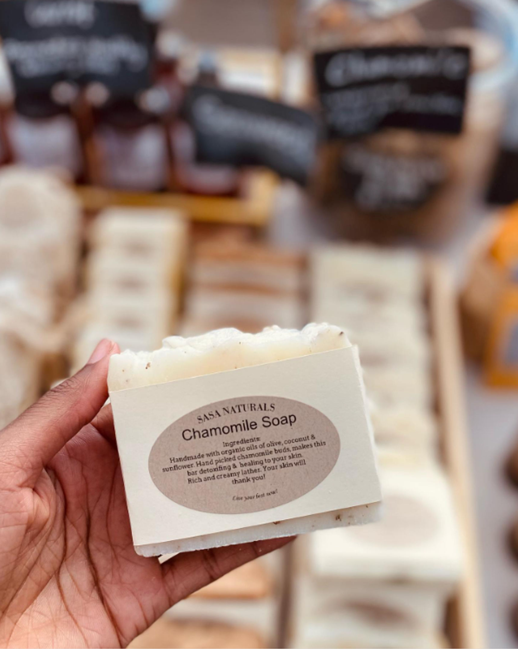 Point of view of woman holding a bar of Sasa Naturals Chamomile Soap 