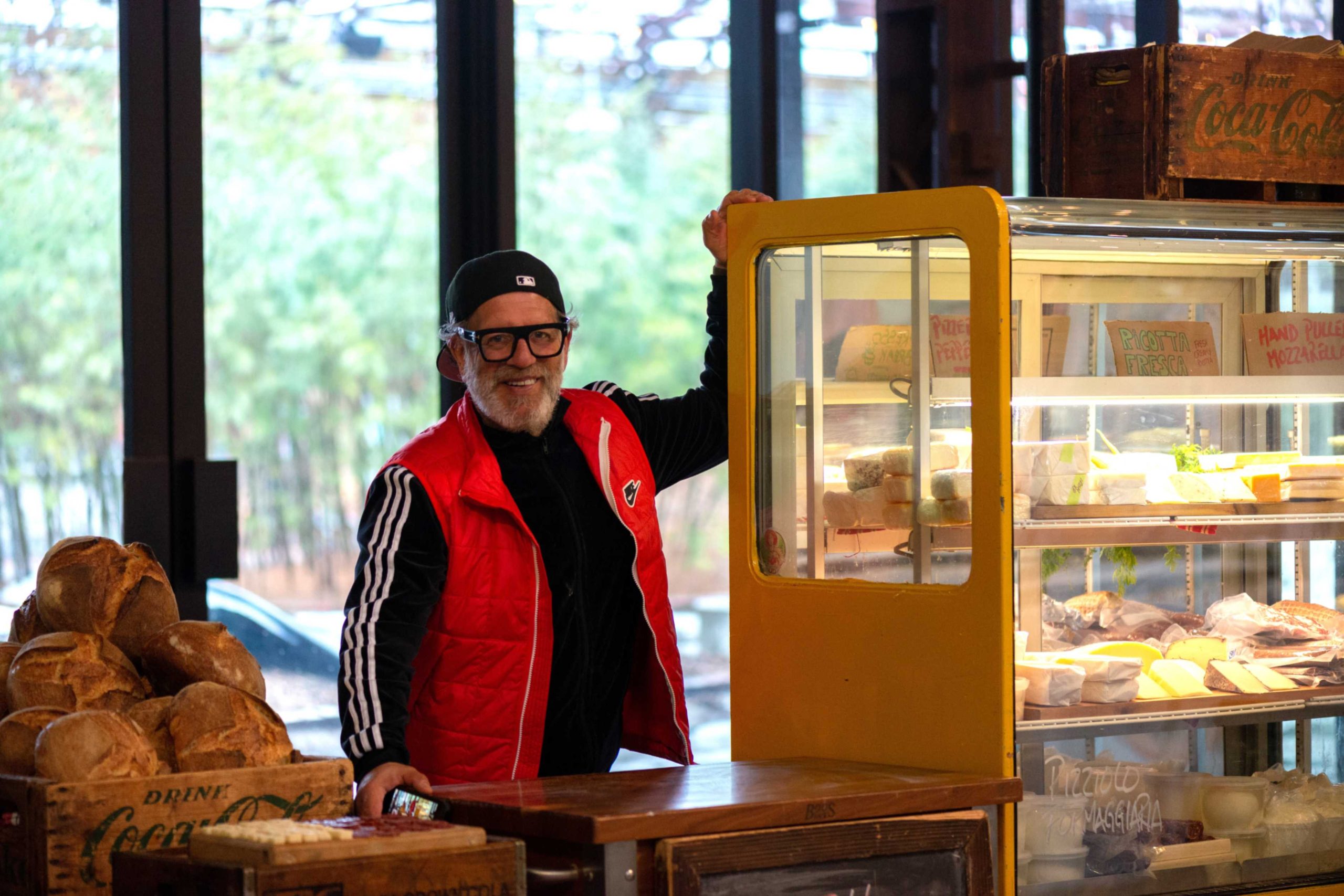 Farmers Market vendor stands next to his display of cheeses at Evergreen Brick Works