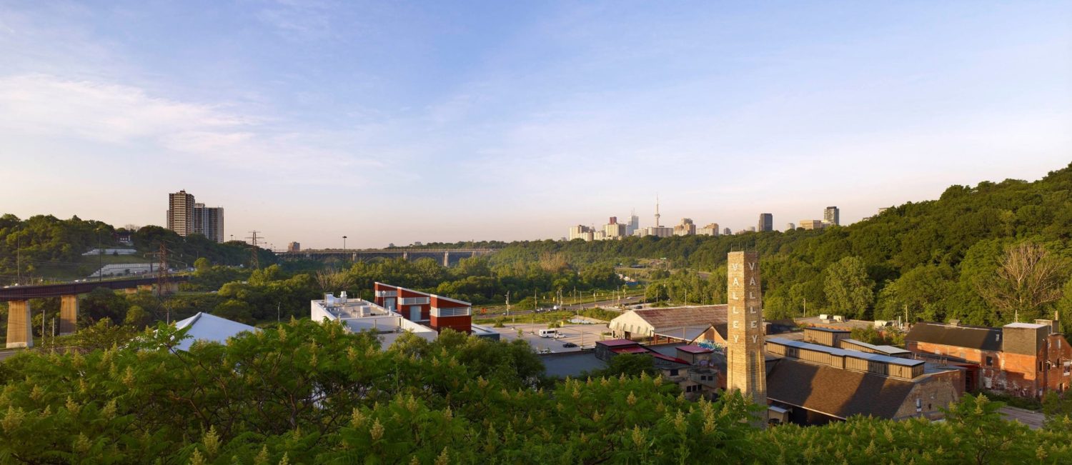 View of Evergreen Brick Works with Toronto skyline in the distance on a summer day