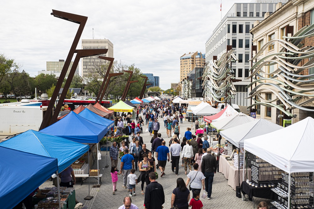 People walk street with market vendors