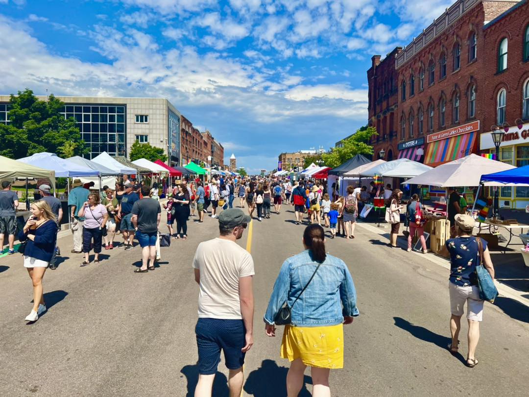 Downtown street closed off to pedestrians walking with market stalls on both sides