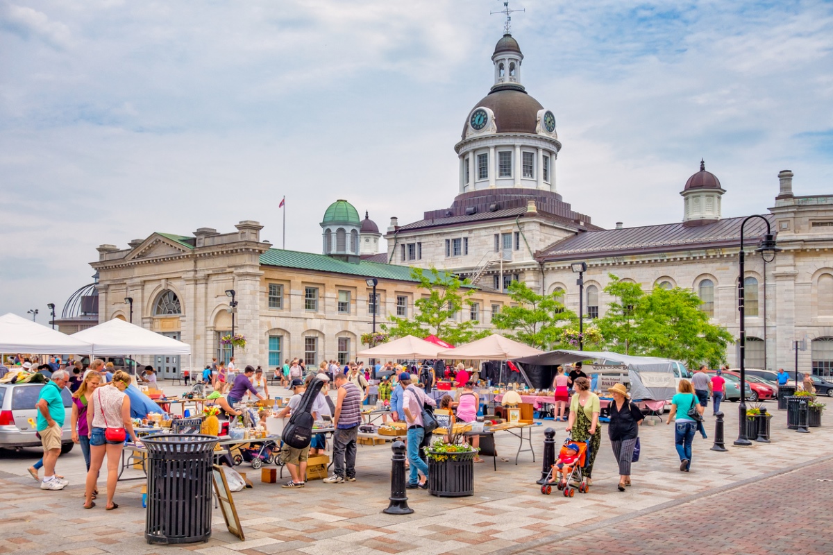 People walk around an market with buildings in the background