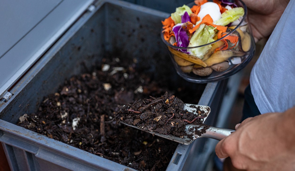 zoom in photo of person mixing food scraps into compost
