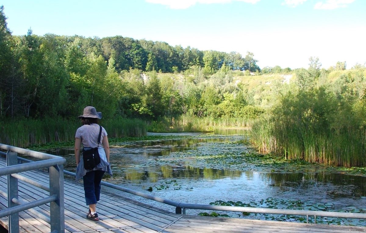 une femme se promène près d'un pond à Evergreen Brick Works 