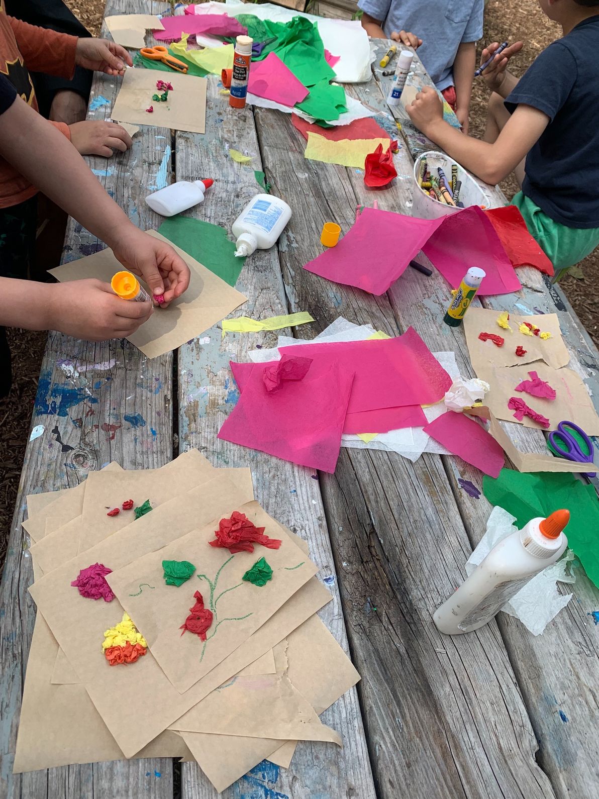 Children make tomato-inspired arts and crafts with tissue paper and glue