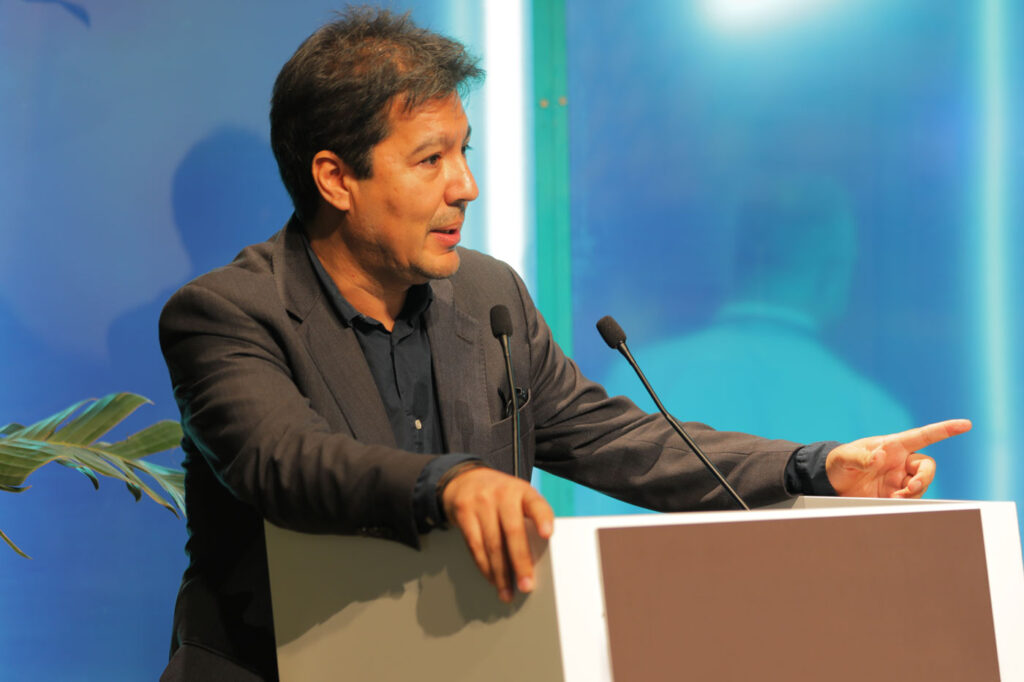 Man stands in front of a podium with a microphone