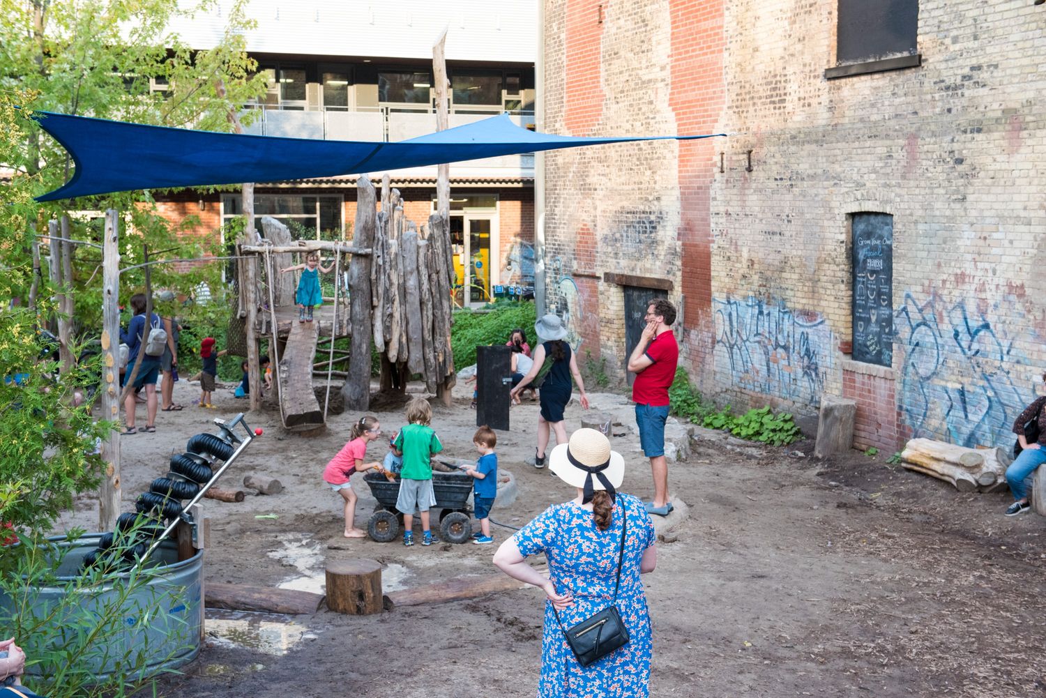 Des parents regardent leurs enfants jouer sur des structures d'escalade en bois