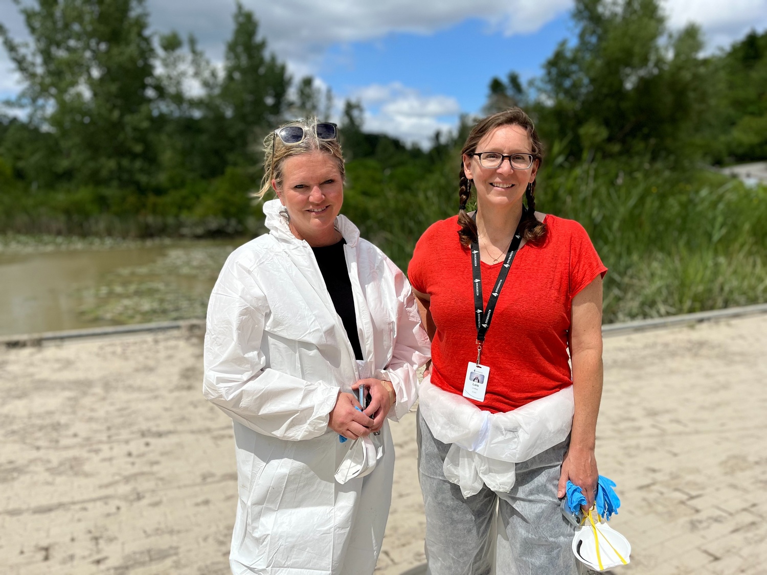 Two women in hazmat suits 