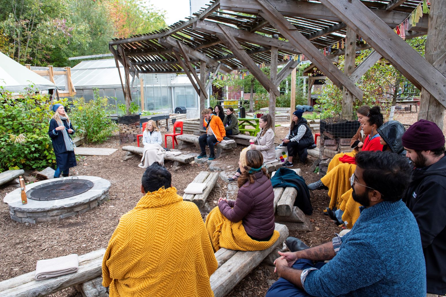 People sat on wooden benches in childrens garden at Evergreen Brick Works