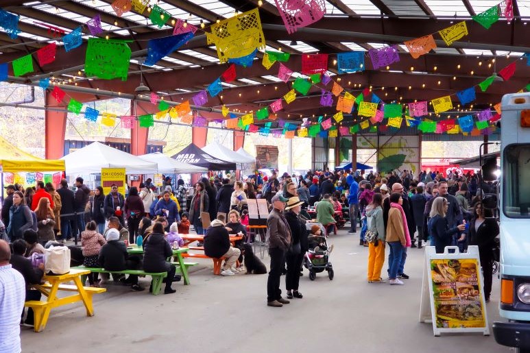 Festival sous le pavillon d'Evergreen Brick Works avec food truck, tables et beaucoup de visiteurs