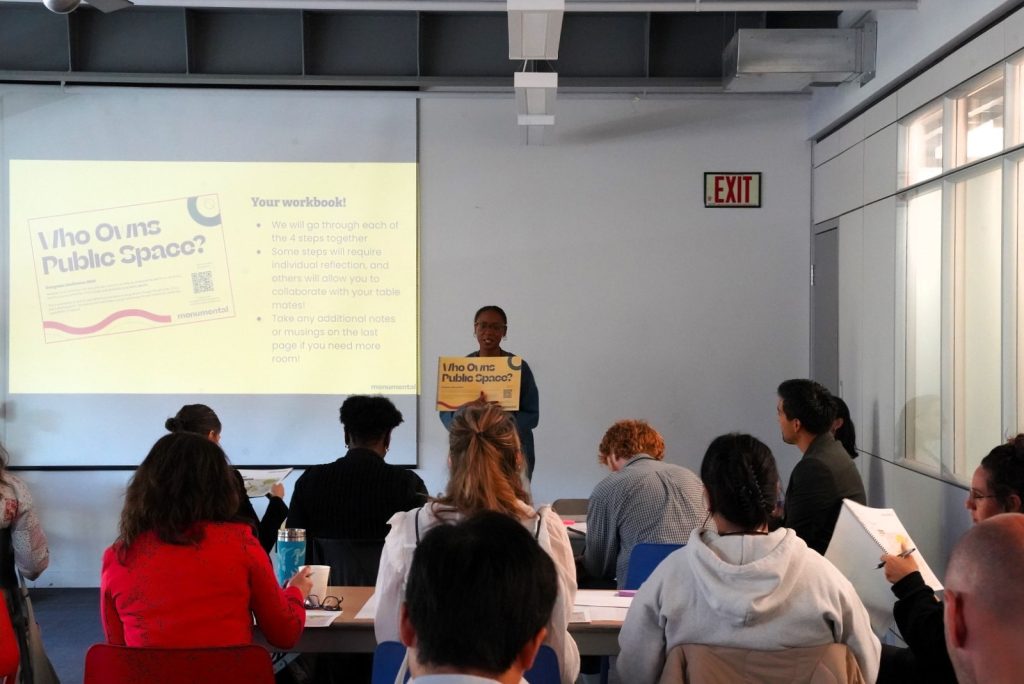 une conférencieère présente l'atelier à un groupe de personnes assises à des tables en groupe