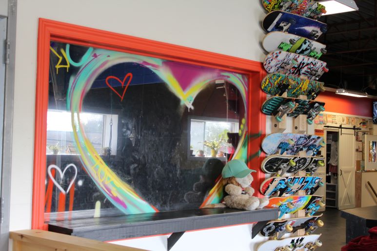 window with a heart mural and skateboards on the wall