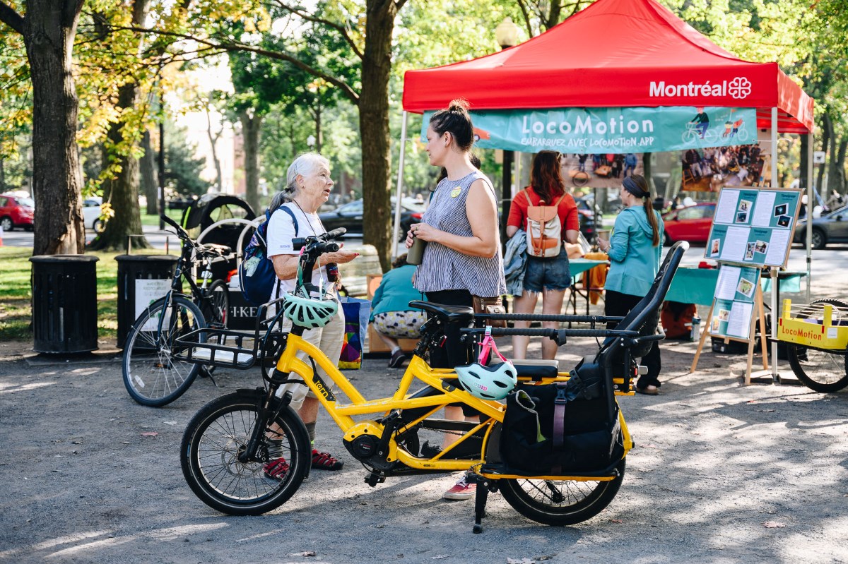 person talking in front of stand of LocoMotion project in montreal