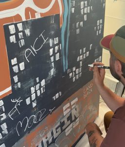 Quinn Hopins en train une des murale de Stellar Narrative