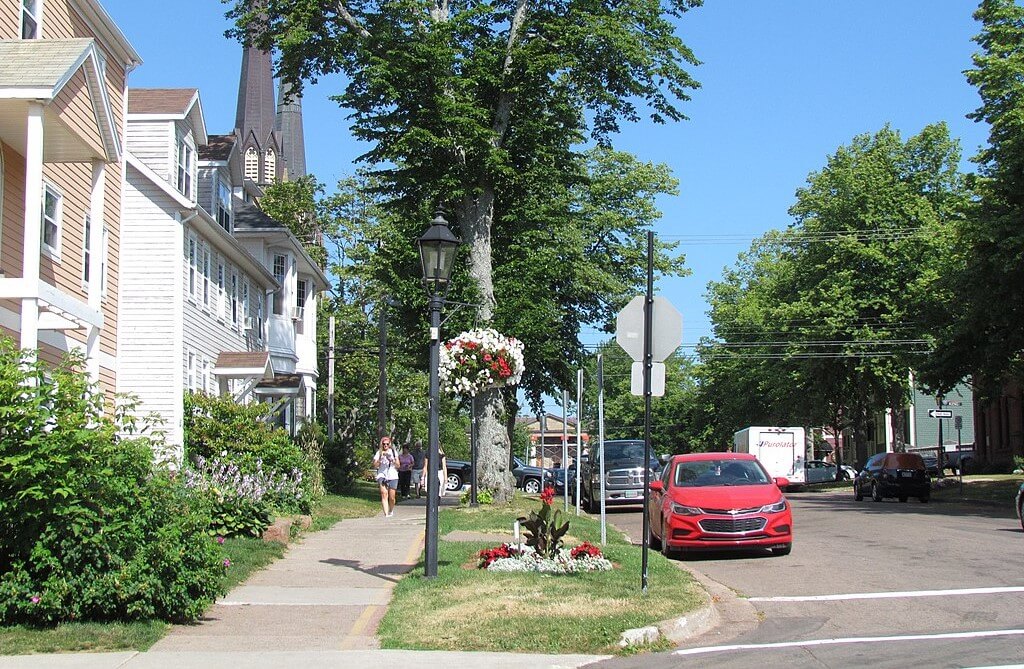 Une rue dans la ville avec des arbres et des maison à l'architecture intéressante
