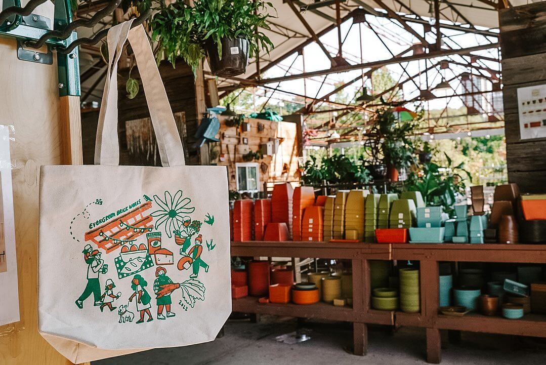 Retail store with items on display like plant pots and tote bags