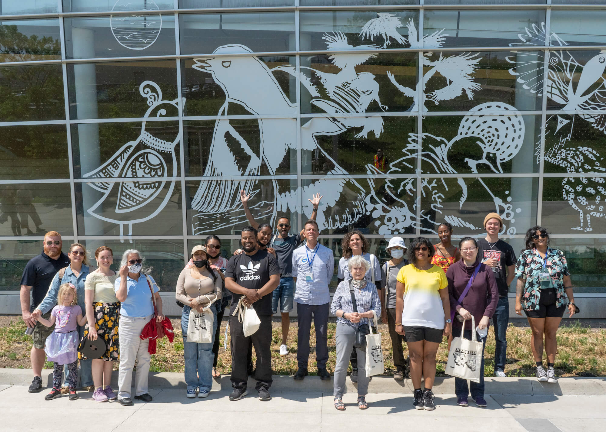 Group of people stand in front of a mural