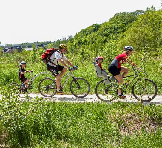 A family goes on a bike ride down a path.