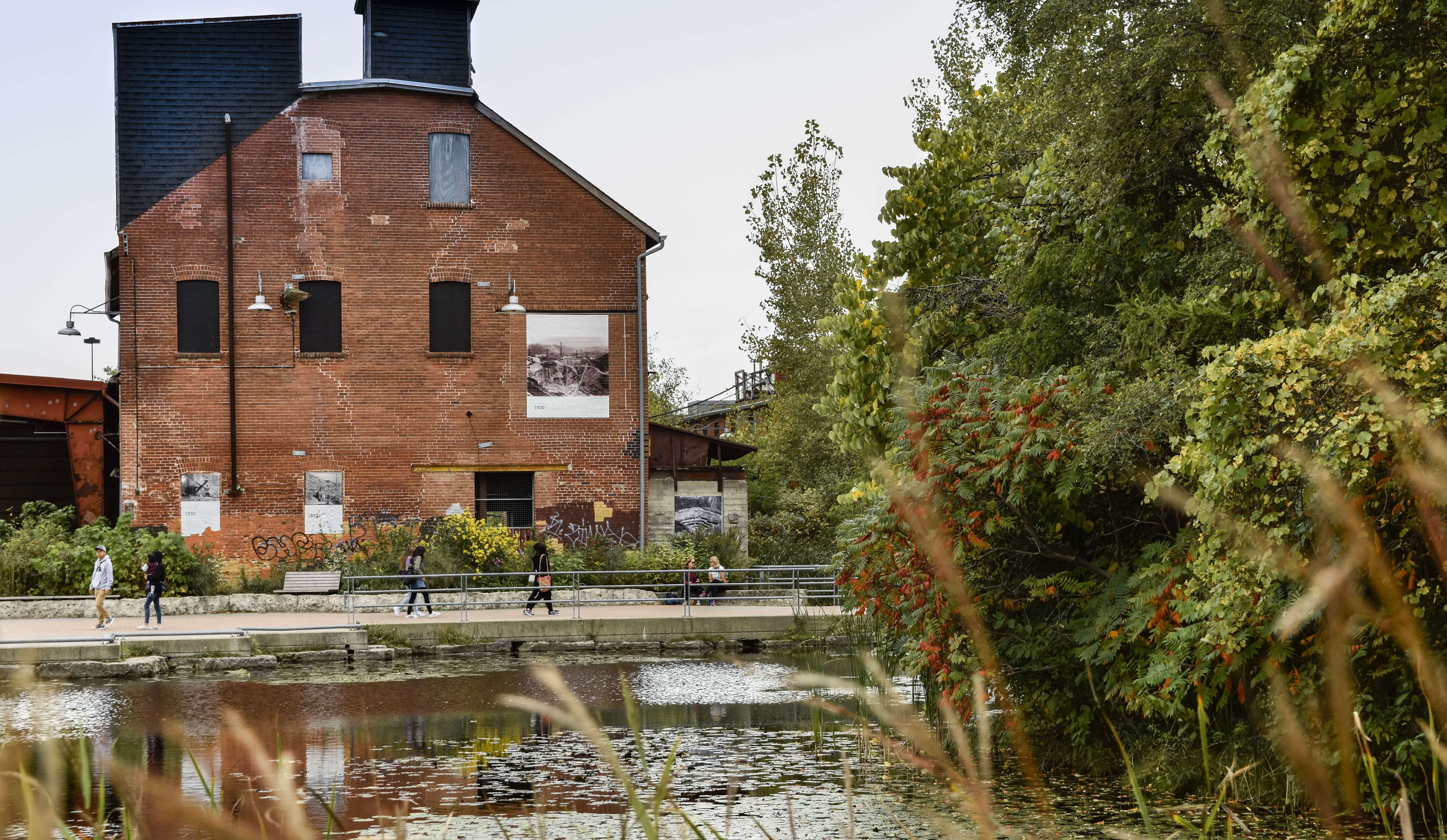 Brick buildings behind pond outdoors