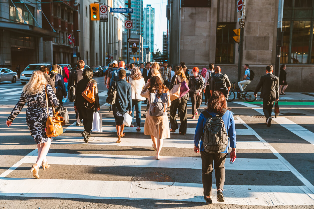 pedestrians walk across street in Toronto