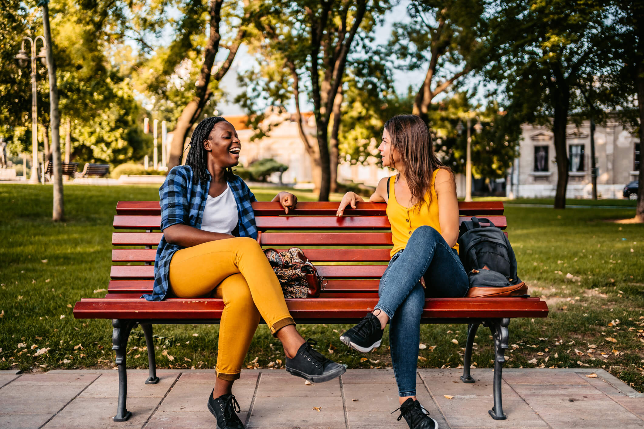 Two people sitting on bench talking