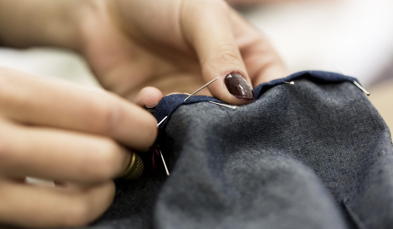Close up of someone repairing clothes sewing